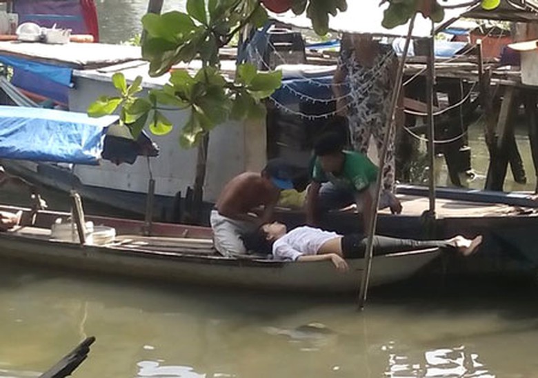 Người phụ nữ được đưa l&ecirc;n ghe v&agrave; sơ cứu tại chỗ, may mắn tho&aacute;t chết.