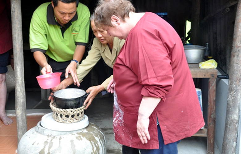 Kh&aacute;ch T&acirc;y học c&aacute;ch vo gạo, thổi lửa nấu cơm bằng bếp củi