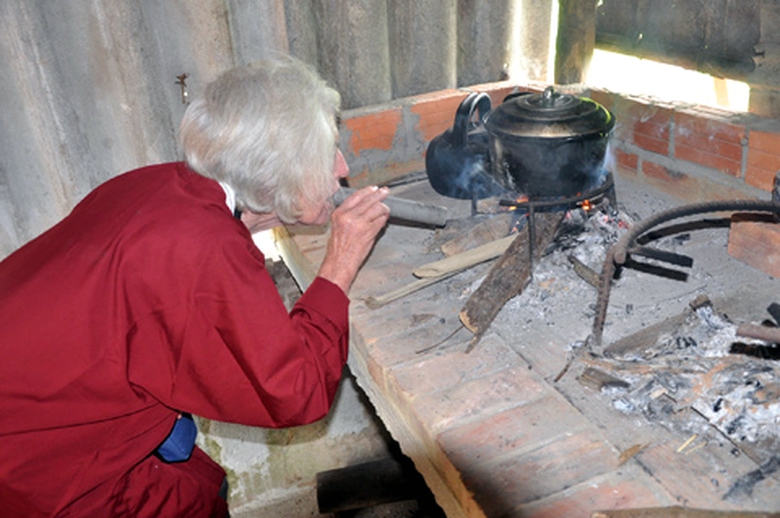 Một vị kh&aacute;ch đang thổi cho lửa ch&aacute;y to hơn