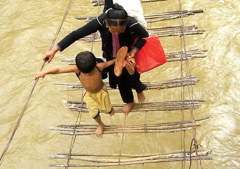 Người d&acirc;n mạo hiểm đ&aacute;nh cược t&iacute;nh mạng khi h&agrave;ng ng&agrave;y phải lưu th&ocirc;ng qua những chiếc cầu treo cũ n&aacute;t (Trong ảnh l&agrave; một c&acirc;y cầu ở x&atilde; Nậm Tăm, huyện S&igrave;n Hồ, Lai Ch&acirc;u)Ảnh: Trần Nhị
