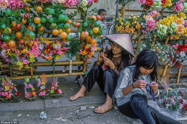 Hai c&ocirc; g&aacute;i b&aacute;n hoa giả tại một g&oacute;c chợ Mỹ Tho