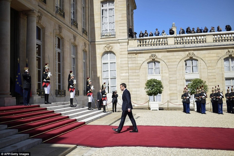 Ông Emmanuel bước trên thảm đỏ, tới cửa