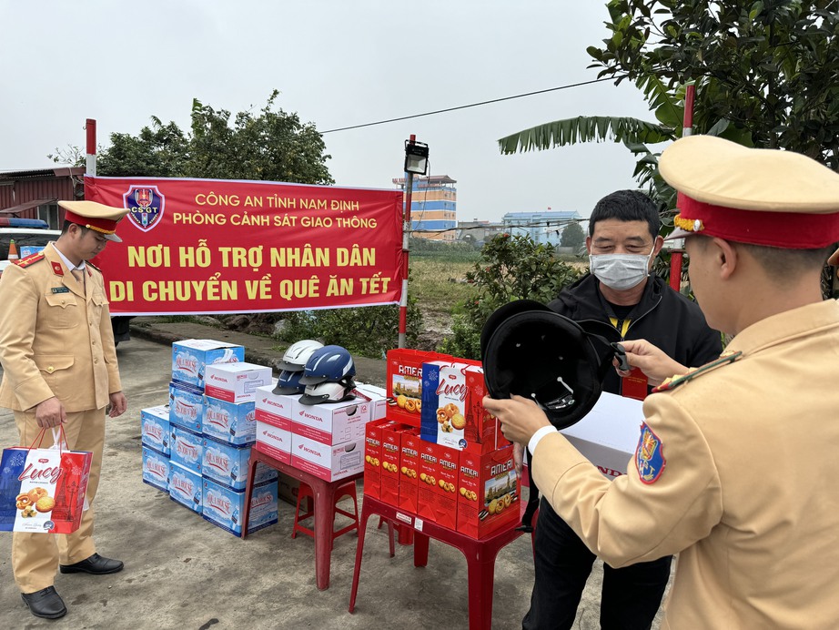 Cảnh s&aacute;t giao th&ocirc;ng Nam Định tặng qu&agrave; nh&acirc;n d&acirc;n tr&ecirc;n đường về qu&ecirc; ăn Tết- Ảnh 2.