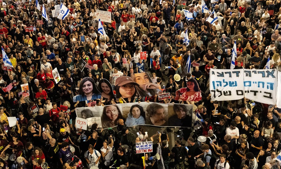 Một số người biểu t&igrave;nh c&ograve;n mang theo ảnh 5 nữ qu&acirc;n nh&acirc;n xuất hiện trong đoạn video bị Hamas bắt giữ l&agrave;m con tin g&acirc;y x&ocirc;n xao dư luận Israel thời gian qua. (Ảnh: AP)