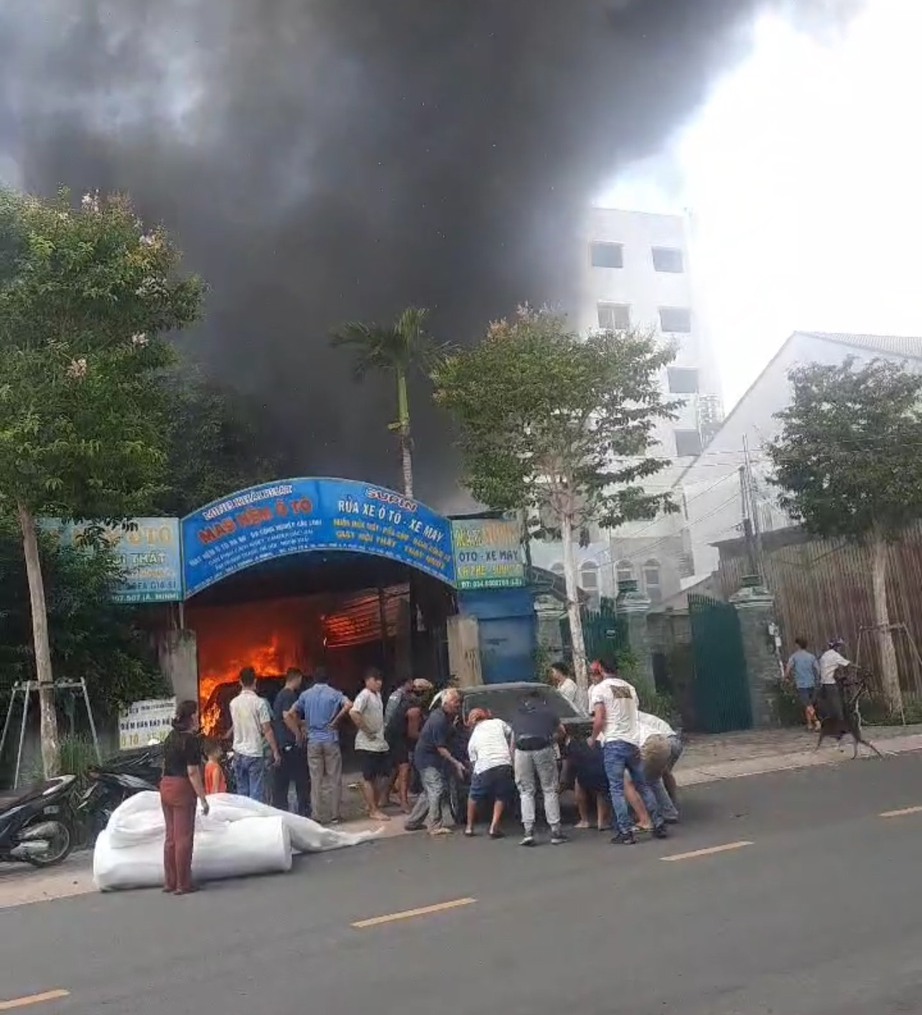 Ch&aacute;y tiệm rửa xe, người d&acirc;n x&uacute;m lại đẩy &ocirc; t&ocirc; ra đường- Ảnh 1.