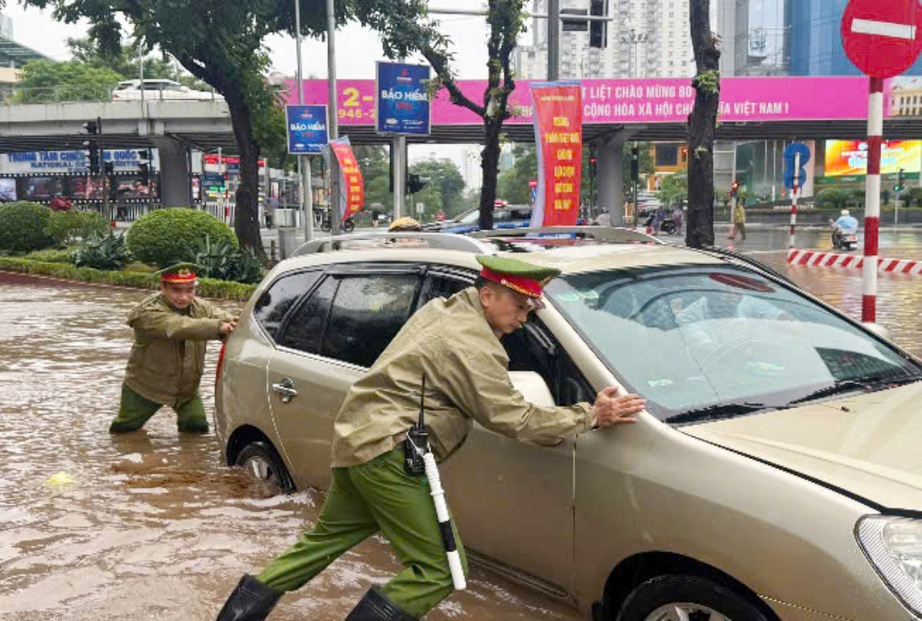 C&ocirc;ng an H&agrave; Nội dầm mưa ph&acirc;n luồng, hỗ trợ người d&acirc;n qua v&ugrave;ng ngập- Ảnh 9.