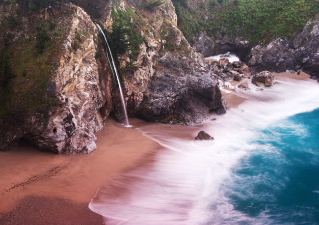 B&atilde;i biển Pfeiffer, Mỹ: Nằm ở khu vực Big Sur thuộc bang California, b&atilde;i biển n&agrave;y c&oacute; c&aacute;t m&agrave;u hồng độc đ&aacute;o. M&agrave;u sắc của n&oacute; bắt nguồn từ đ&aacute; chứa ma-gi&ecirc; hồng từ c&aacute;c v&aacute;ch n&uacute;i xung quanh.
