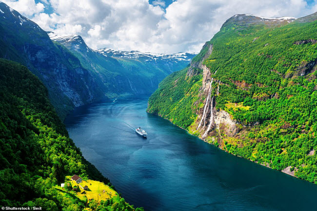 Du thuyền di chuyển dưới vịnh Geirangerfjord. Bờ b&ecirc;n phải l&agrave; th&aacute;c Seven Sisters, bao gồm 7 d&ograve;ng suối cao 410m.