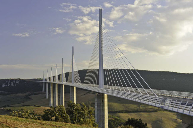 Cầu Millau Viaduct, Ph&aacute;p: Gần 600 c&ocirc;ng nh&acirc;n l&agrave;m việc suốt 3 năm mới ho&agrave;n th&agrave;nh c&acirc;y cầu Millau Viaduct, kết nối th&agrave;nh phố Clermont-Ferrand với thị trấn B&eacute;ziers. C&ocirc;ng tr&igrave;nh g&acirc;y ấn tượng với thiết kế hiện đại.