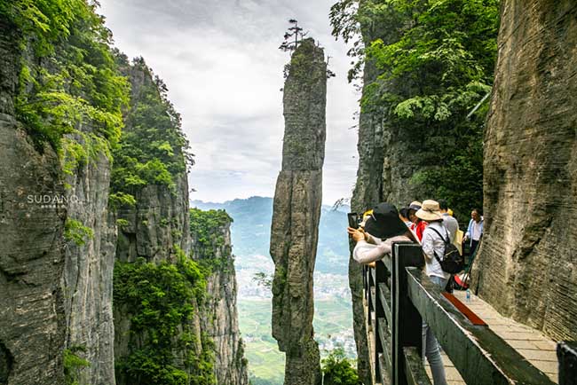 Điểm nổi bật nhất của hẻm n&uacute;i n&agrave;y l&agrave; Yizhuxiang. Yizhuxiang thực chất l&agrave; một cột đ&aacute; nh&igrave;n kh&aacute; mảnh mai, ở giữa 2 v&aacute;ch n&uacute;i lớn. H&igrave;nh d&aacute;ng v&agrave; vị tr&iacute; của n&oacute; khiến người ta c&oacute; cảm gi&aacute;c như sắp đổ, nhưng thực tế n&oacute; đ&atilde; đứng vững ch&atilde;i suốt h&agrave;ng chục triệu năm.