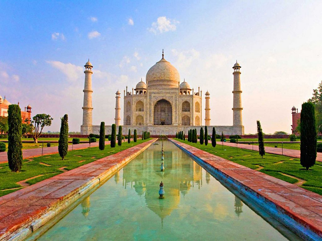 Taj Mahal l&agrave; một kiệt t&aacute;c kiến tr&uacute;c tuyệt đẹp được x&acirc;y dựng bằng đ&aacute; cẩm thạch trắng v&agrave; l&agrave; đ&agrave;i tưởng niệm nổi tiếng nhất của Ấn Độ, nơi lưu giữ lăng mộ vợ của cựu ho&agrave;ng đế Mughal. H&igrave;nh ảnh phản chiếu của Taj Mahal xuống hồ nước ph&iacute;a trước v&ocirc; c&ugrave;ng ngoạn.

