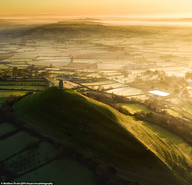 Một bức ảnh tuyệt đẹp của Glastonbury Tor mang t&iacute;nh biểu tượng. Đ&oacute; l&agrave; một ngọn đồi tr&ecirc;n đỉnh l&agrave; Th&aacute;p St Michael được bao xung quanh bởi những b&iacute; ẩn v&agrave; truyền thuyết đ&atilde; xoay vần trong nhiều thế kỷ.&nbsp;

