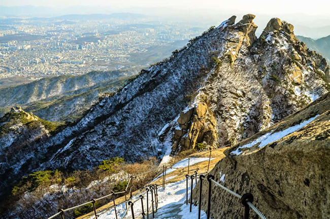 Vườn quốc gia Bukhansan: Đ&acirc;y l&agrave; một c&ocirc;ng vi&ecirc;n quốc gia bằng đ&aacute; tuyệt đẹp nằm ngay ph&iacute;a tr&ecirc;n Seoul. Bạn c&oacute; thể dễ d&agrave;ng bắt đầu chuyến đi bộ h&ograve;a m&igrave;nh với thi&ecirc;n nhi&ecirc;n bằng phương tiện giao th&ocirc;ng c&ocirc;ng cộng.
