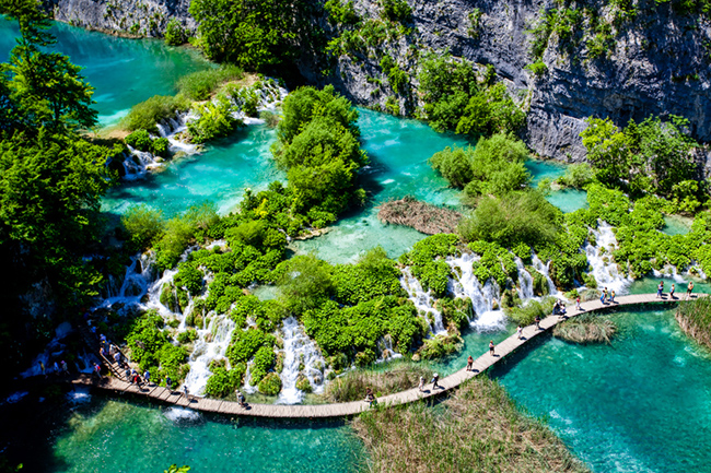 Vườn quốc gia Plitvice Lakes, Croatia: Ẩn m&igrave;nh giữa hai ngọn n&uacute;i l&agrave; 16 hồ nước xếp tầng tạo n&ecirc;n vườn quốc gia Plitvice Lakes. C&aacute;c hồ nước trong xanh nguy&ecirc;n sơ được ngăn c&aacute;ch bởi c&aacute;c đập tự nhi&ecirc;n bằng đ&aacute;&nbsp;v&agrave; bao quanh bởi c&aacute;c th&aacute;c nước, rừng sồi v&agrave; linh sam c&ugrave;ng c&aacute;c hang động ẩn.

