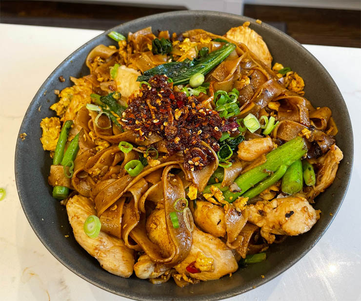 12. Pad See Ew cũng l&agrave; một m&oacute;n mỳ x&agrave;o v&agrave; n&oacute; chịu ảnh hưởng của ẩm thực Trung Quốc. M&oacute;n mỳ n&agrave;y được x&agrave;o c&ugrave;ng với nước tương, cải xoăn, trứng, v&agrave; thịt g&agrave;, vừa b&eacute;o ngậy vừa ngon miệng.
