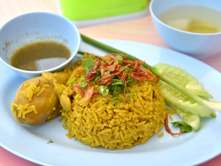 9. Khao Mok Gai l&agrave; một m&oacute;n cơm g&agrave; điển h&igrave;nh, cơm v&agrave;ng tươi v&agrave; thơm do được ng&acirc;m trong nghệ, ăn k&egrave;m với dưa chuột, tương ớt ngọt v&agrave; một c&aacute;i đ&ugrave;i đ&agrave;. M&oacute;n ăn n&agrave;y c&oacute; nguồn gốc từ người d&acirc;n theo đạo Hồi ở Th&aacute;i Lan nhưng được mọi người ưa chuộng.
