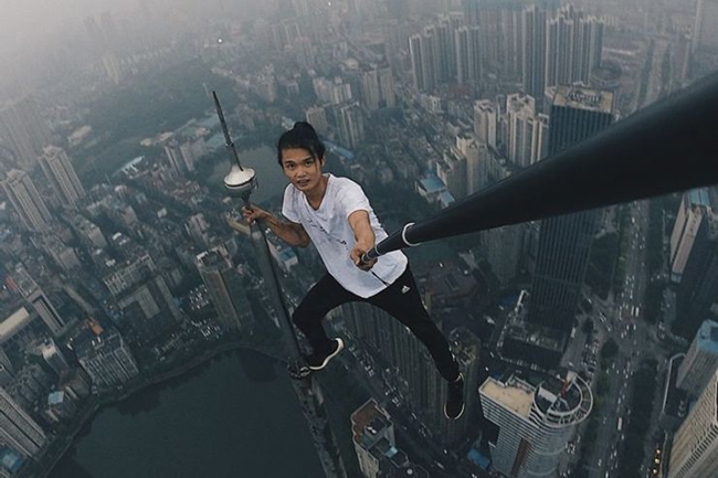 Đỉnh th&aacute;p ở HongKong: Bức ảnh n&agrave;y m&ocirc; tả một lần nữa Wu Yongning, người thanh ni&ecirc;n trẻ tuổi c&oacute; biệt danh l&agrave; "người tr&ecirc;n n&oacute;c nh&agrave;" th&iacute;ch leo l&ecirc;n đỉnh của c&aacute;c t&ograve;a nh&agrave; v&agrave; c&ocirc;ng tr&igrave;nh kiến ​​tr&uacute;c cao đến mức n&agrave;o.
