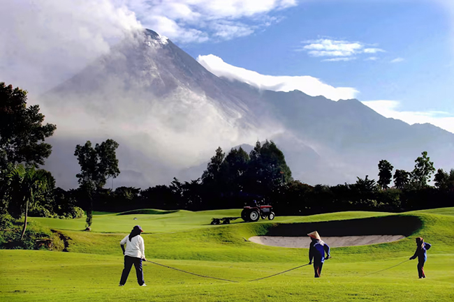The Volcanic One - Merapi Golf Club, Slemen, Indonesia: Mặc d&ugrave; đ&acirc;y l&agrave; một s&acirc;n golf tuyệt đẹp nhưng đừng để vẻ bề ngo&agrave;i đ&oacute; lừa,&nbsp;bởi ngọn n&uacute;i h&ugrave;ng vĩ ở ph&iacute;a sau ch&iacute;nh l&agrave; n&uacute;i Merapi, một trong những ngọn n&uacute;i lửa hoạt động mạnh nhất tr&ecirc;n h&agrave;nh tinh. Chơi golf ở đ&acirc;y, bạn sẽ nh&igrave;n thấy kh&oacute;i cuồn cuộn tr&ecirc;n&nbsp;đỉnh n&uacute;i.