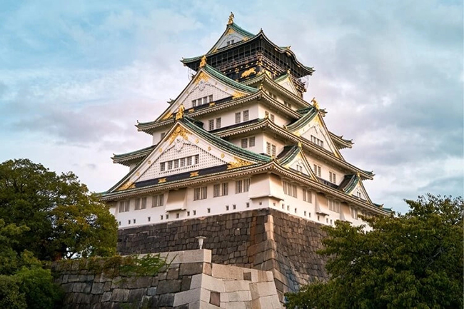 L&acirc;u đ&agrave;i Osaka l&agrave; một trong những địa danh lịch sử n&ecirc;n đến thăm ở Nhật Bản. Ngo&agrave;i mang t&iacute;nh lịch sử, bản th&acirc;n l&acirc;u đ&agrave;i cũng l&agrave; một kiệt t&aacute;c&nbsp;kiến tr&uacute;c với sự kết hợp của m&agrave;u trắng v&agrave; xanh l&aacute; c&acirc;y đầy ấn tượng, với&nbsp;con h&agrave;o c&ugrave;ng khu&ocirc;n vi&ecirc;n rất xinh đẹp. Th&aacute;p trung t&acirc;m cao 5 tầng v&agrave; được trang tr&iacute; bằng v&agrave;ng l&aacute;.
