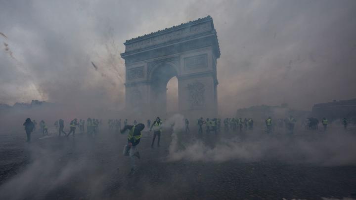 1/12: Kh&iacute; gas bao quanh những người biểu t&igrave;nh &ldquo;&Aacute;o v&agrave;ng&rdquo; khi họ đụng độ với cảnh s&aacute;t gần Khải Ho&agrave;n M&ocirc;n của Paris. Chi ph&iacute; ng&agrave;y c&agrave;ng tăng của xăng v&agrave; nhi&ecirc;n liệu diesel đ&atilde; l&agrave;m dấy l&ecirc;n c&aacute;c cuộc biểu t&igrave;nh rộng lớn hơn chống lại ch&iacute;nh phủ của Tổng thống Macron.