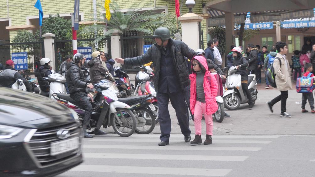 Trật tự phường Điện Bi&ecirc;n, Ba Đ&igrave;nh tận t&igrave;nh dẫn c&aacute;c em học sinh trường Phan Chu Trinh (nằm tr&ecirc;n đường Nguyễn Th&aacute;i Học) sang đường an to&agrave;n.