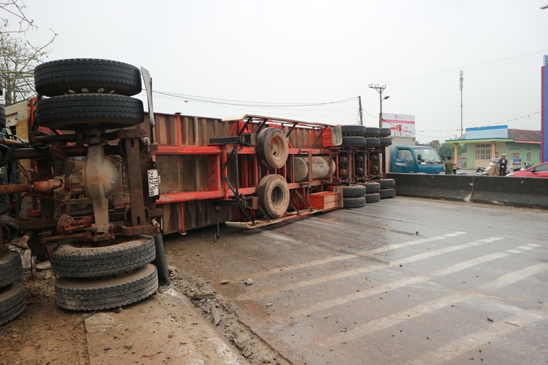 Cạnh đ&oacute; l&agrave; chiếc xe container bị lật nghi&ecirc;ng sau khi t&ocirc;ng v&agrave;o nh&agrave; d&acirc;n