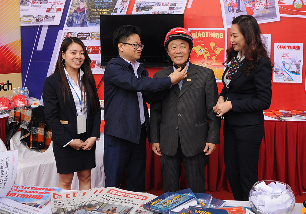 Với c&acirc;u trả lời đ&uacute;ng, kh&aacute;ch tham quan được thưởng mũ bảo hiểm đạt chuẩn, trị gi&aacute; 250.000 đồng/chiếc. To&agrave;n bộ số tiền mua s&aacute;ch, b&aacute;o được d&ugrave;ng để g&acirc;y Qũy Chung tay v&igrave; An to&agrave;n giao th&ocirc;ng - hỗ trợ c&aacute;c gia đ&igrave;nh kh&oacute; khăn c&oacute; người th&acirc;n bị TNGT (Trong ảnh: Ph&oacute; Tổng bi&ecirc;n tập Nguyễn Văn Hường trao MBH cho một độc giả lớn tuổi trả lời đ&uacute;ng c&acirc;u hỏi)