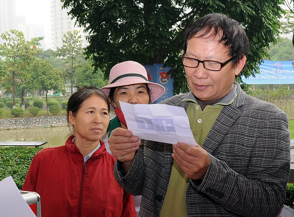 C&ocirc; Nguyễn Thị Kim Xuyến, phường Lĩnh Nam, quận Ho&agrave;ng Mai, H&agrave; Nội (&aacute;o đỏ) t&ograve; m&ograve; v&igrave; sự nhộn nhịp của gian h&agrave;ng