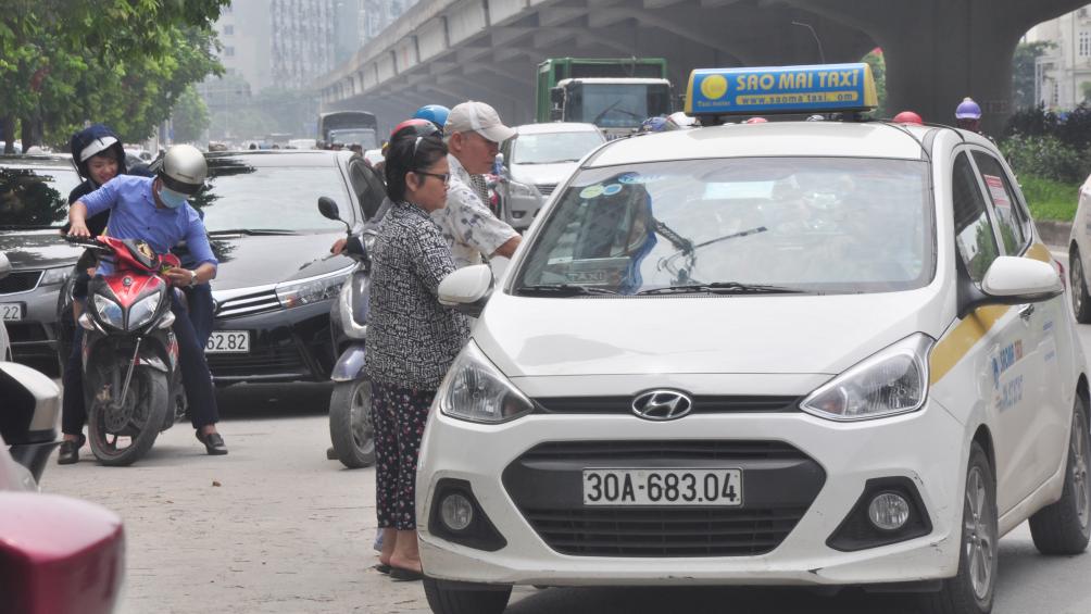 Đoạn đường n&agrave;y đang giống như một bến đỗ, bắt kh&aacute;ch của xe taxi truyền thống v&agrave; taxi c&ocirc;ng nghệ