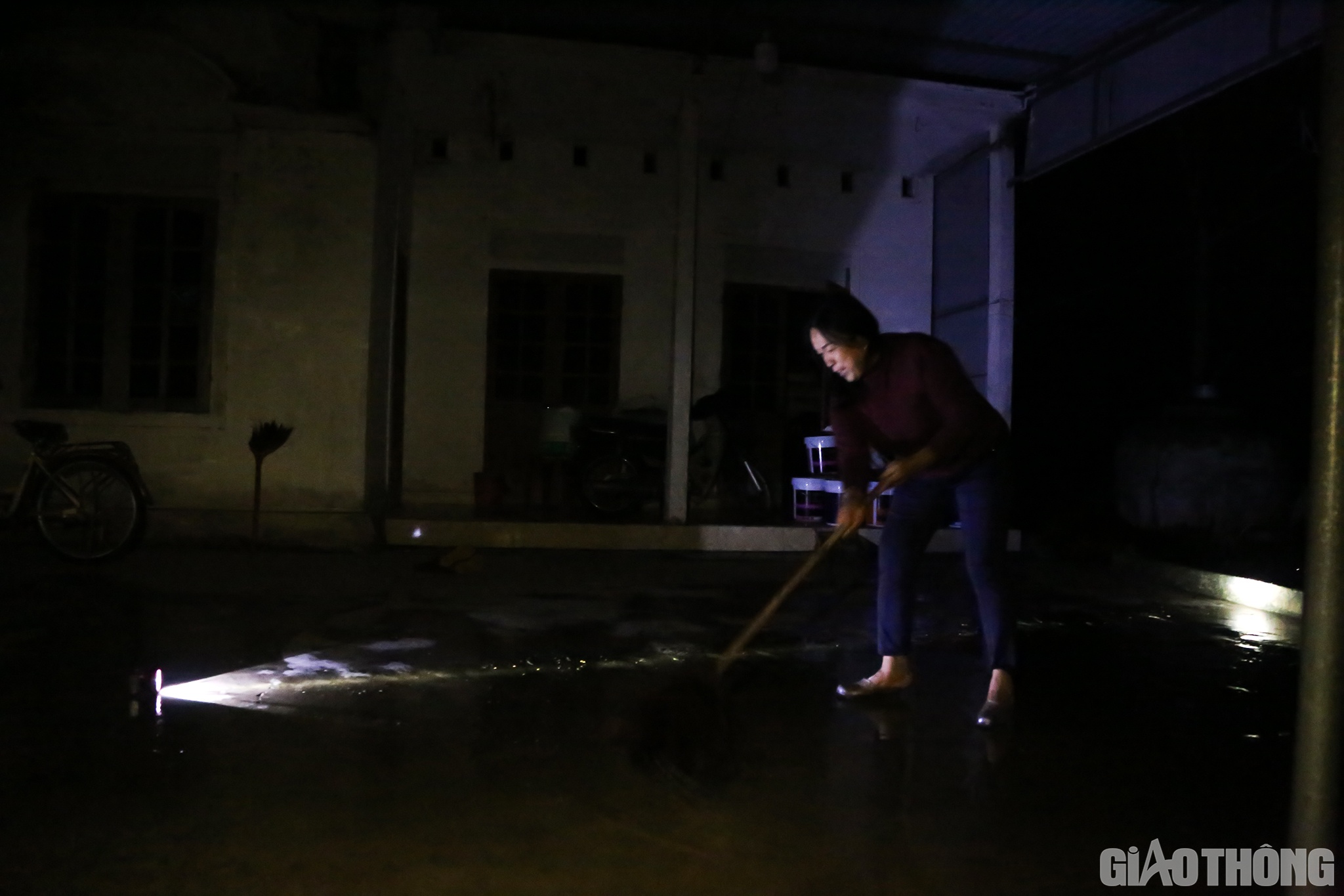 Trong khi đ&oacute;, chị Nguyễn Thị Cương (th&ocirc;n Vinh Quang, x&atilde; Cẩm B&igrave;nh) lại đang tranh thủ nước r&uacute;t đến đ&acirc;u dọn dẹp đến đ&oacute; để dễ d&agrave;ng cọ rửa b&ugrave;n đất.