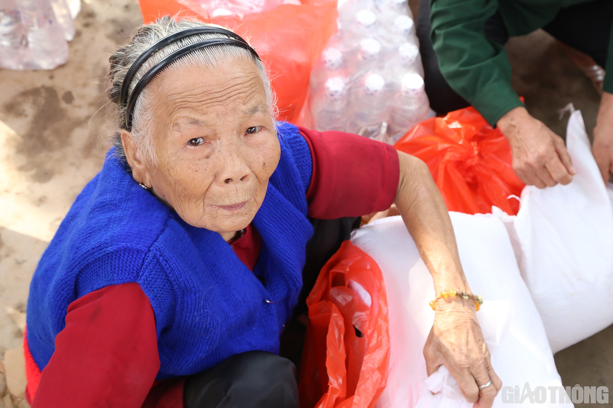 Cụ b&agrave; L&ecirc; Thị Đ&igrave;a (90 tuổi, ở th&ocirc;n Đ&ocirc;ng 2, x&atilde; Hiền Ninh ng&acirc;n ngấn nước mắt khi đ&oacute;n nhận c&aacute;c m&oacute;n qu&agrave; của B&aacute;o Giao th&ocirc;ng v&agrave; nh&agrave; t&agrave;i trợ.