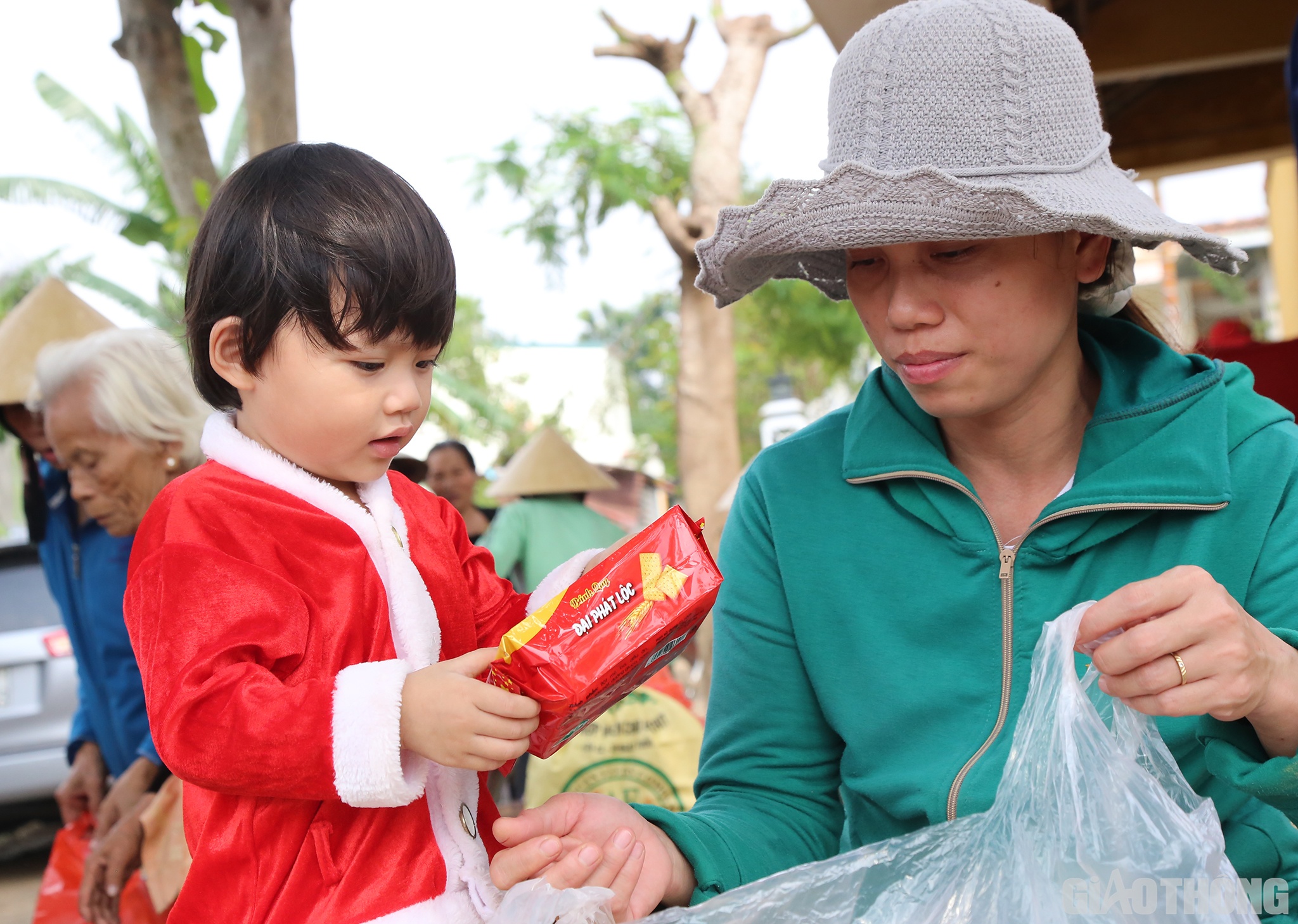 B&eacute; B&ugrave;i Ngọc Nh&atilde; Quy&ecirc;n (3 tuổi, ở th&ocirc;n Đ&ocirc;ng 2, x&atilde; Hiền Ninh) được mẹ cho g&oacute;i b&aacute;nh được lấy ra từ t&uacute;i qu&agrave; của B&aacute;o Giao th&ocirc;ng v&agrave; c&aacute;c nh&agrave; t&agrave;i trợ.