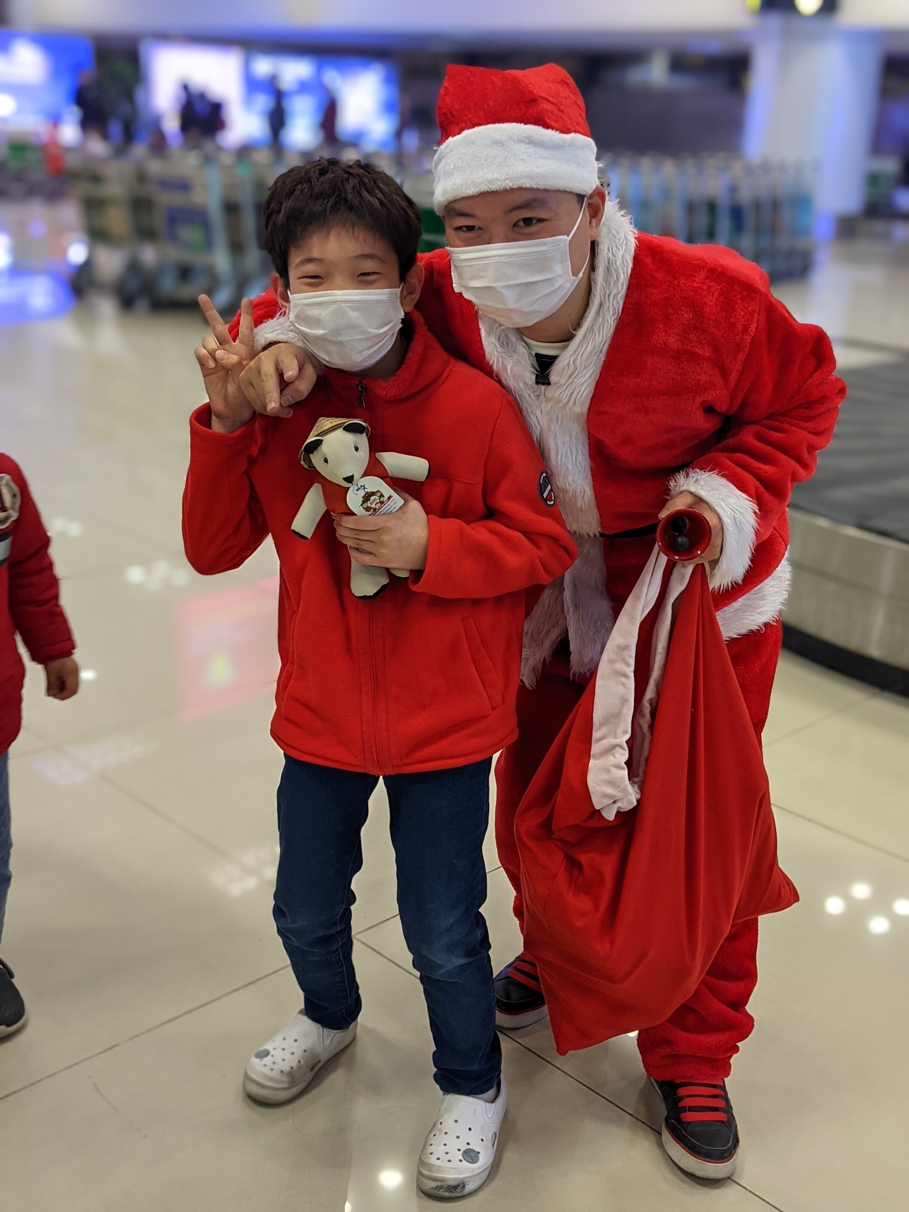 Một b&eacute; trai h&agrave;o hứng tạo d&aacute;ng với Santas NIA