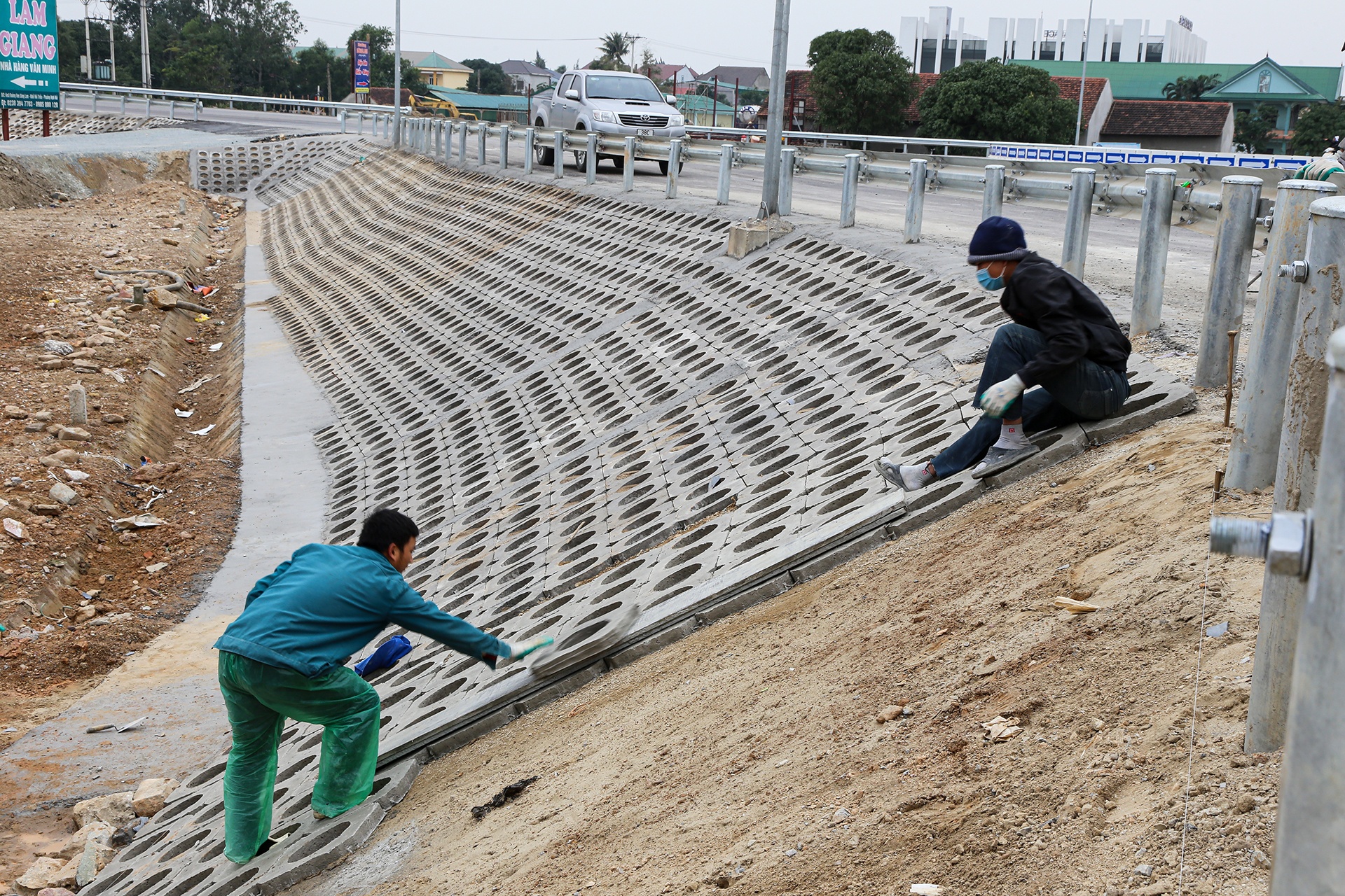 Ở ph&iacute;a c&ograve;n lại của đường dẫn n&agrave;y, c&aacute;c c&ocirc;ng nh&acirc;n đang l&aacute;t những vi&ecirc;n gạch ốp m&aacute;i cuối c&ugrave;ng.