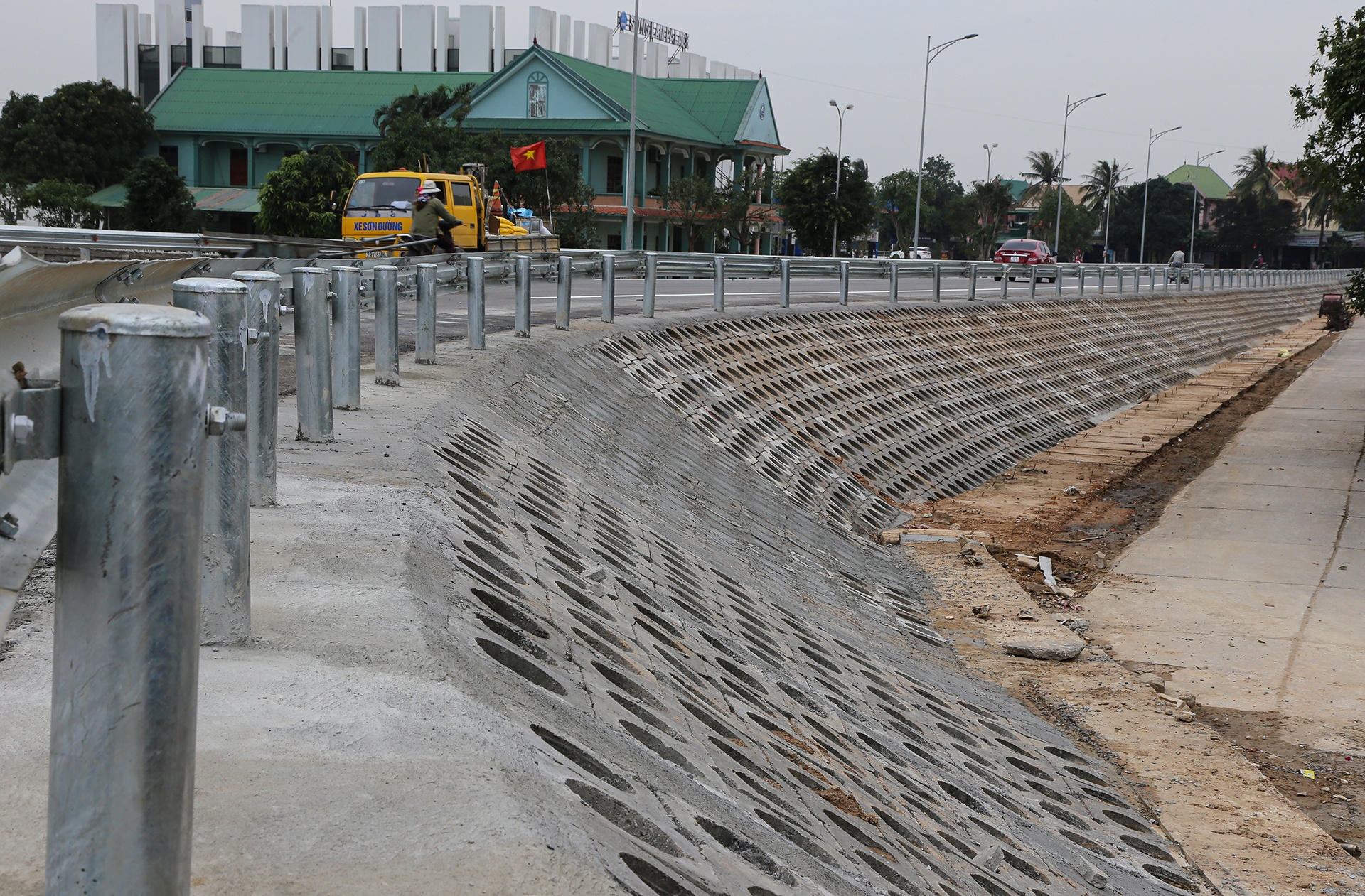 Một m&aacute;i taluy ở đường dẫn đầu cầu ph&iacute;a tỉnh Nghệ An đ&atilde; ho&agrave;n thiện xong.