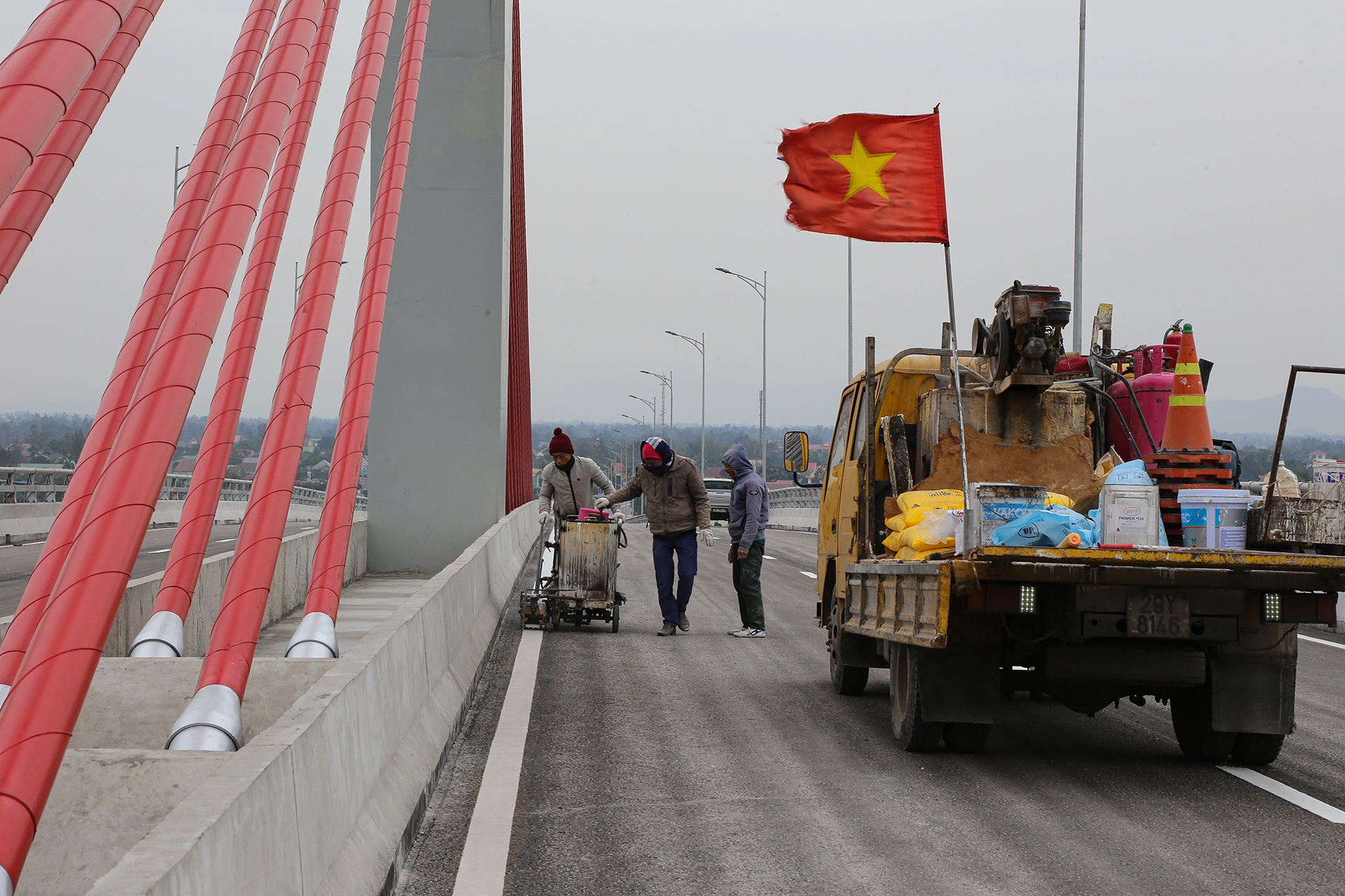 Ở tr&ecirc;n cầu, c&aacute;c c&ocirc;ng nh&acirc;n cũng đang ho&agrave;n thiện sơn vạch kẻ đường