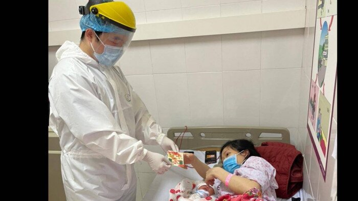 B&aacute;c sỹ Bệnh viện Sản Nhi mừng tuổi cho một bệnh nh&acirc;n. Tết n&agrave;y, mọi y, b&aacute;c sĩ ai cũng phải xa nh&agrave;, nhưng họ đều dốc l&ograve;ng điều trị v&agrave; chăm lo Tết chu đ&aacute;o cho c&aacute;c bệnh nh&acirc;n.
