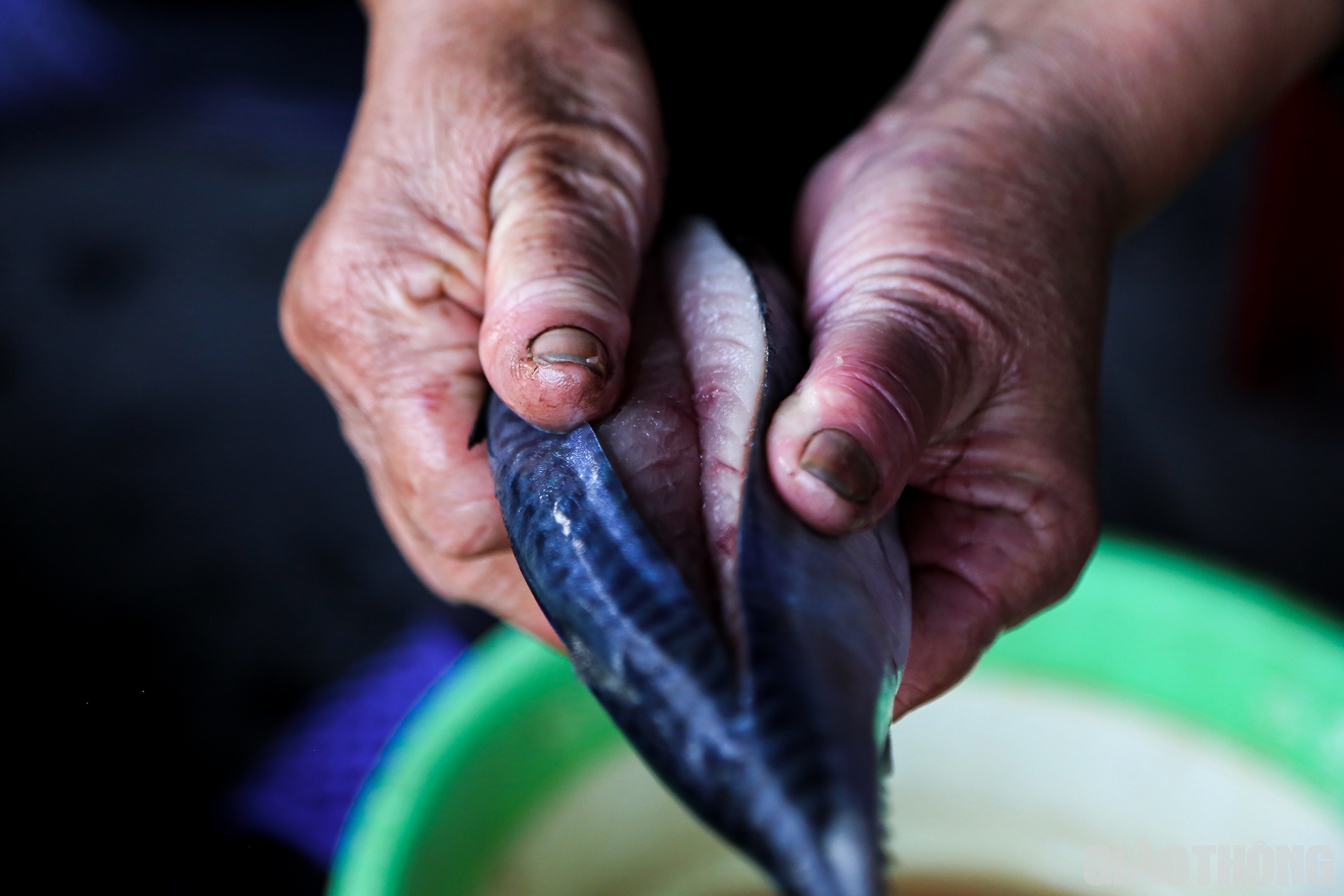 Người thợ nướng c&aacute; d&ugrave;ng tay nắn nhẹ để phần rạch hở ra, khoe những thớ thịt tươi ngon b&ecirc;n trong con c&aacute;