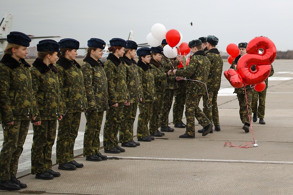 C&aacute;c nam đồng nghiệp tặng hoa cho những c&ocirc; g&aacute;i trước phi&ecirc;n bay huấn luyện.