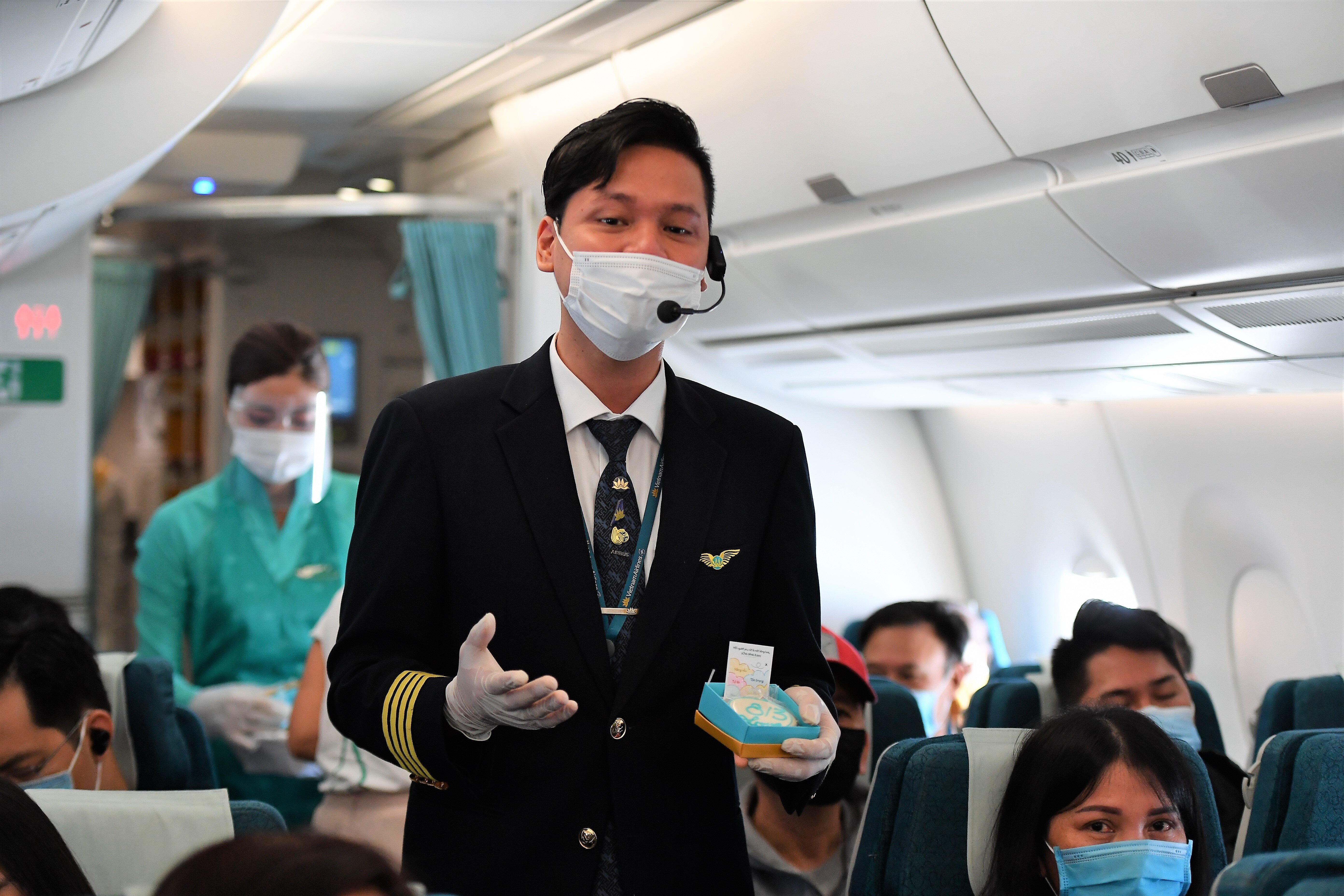 Một phi c&ocirc;ng nam của Vietnam Airlines h&aacute;t tặng h&agrave;nh kh&aacute;ch tr&ecirc;n chuyến bay
