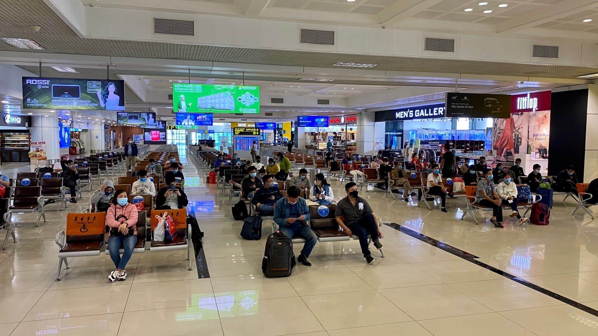 Định kỳ h&agrave;ng tuần tiến h&agrave;nh phun khử khuẩn luồng tuyến di chuyển của kh&aacute;ch, quầy thủ tục, lối đi kiểm so&aacute;t an ninh, cửa ra t&agrave;u bay, cầu ống lồng; to&agrave;n bộ khu vực nội địa đến/ nội địa đi; Tăng cường vệ sinh to&agrave;n bộ c&aacute;c bề mặt tiếp x&uacute;c m&agrave; h&agrave;nh kh&aacute;ch thường chạm đến tại c&aacute;c khu vực của nh&agrave; ga h&agrave;nh kh&aacute;ch. Trong ảnh, ghế ngồi trong ph&ograve;ng chờ ra t&agrave;u bay được d&aacute;n decal gi&atilde;n c&aacute;ch