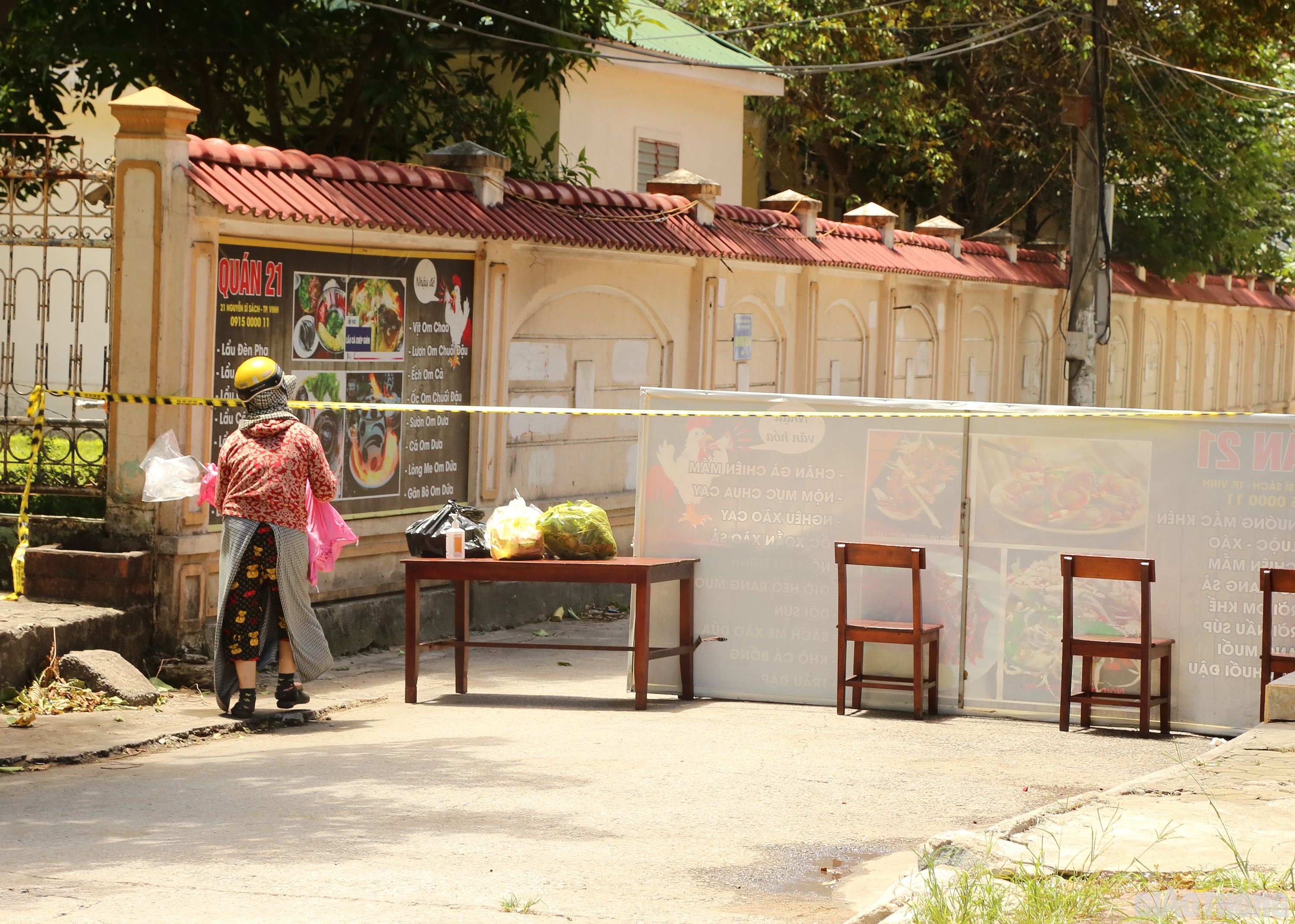 Gần đ&oacute;, d&ugrave; giữa trưa h&egrave; nắng ch&aacute;y da ch&aacute;y thịt nhưng v&igrave; c&oacute; người th&acirc;n ở trong khu vực phong tỏa của phường H&agrave; Huy Tập cần đồ ăn n&ecirc;n chị Nguyễn Thị Thủy (55 tuổi, ở Cửa Hội) vẫn phải lặn lội đem l&ecirc;n.  Ảnh: Sỹ H&ograve;a