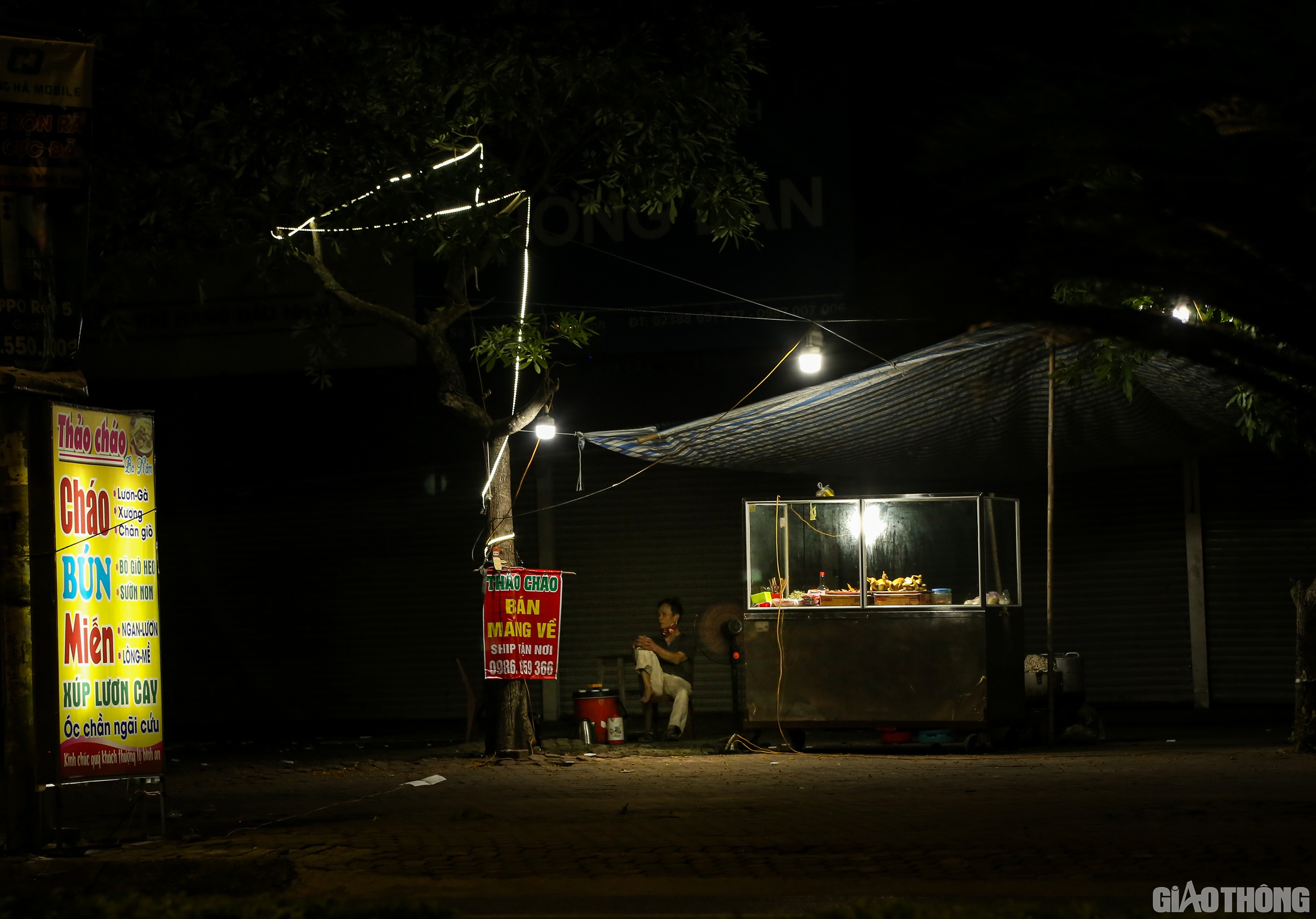 Một qu&aacute;n ăn đ&ecirc;m tr&ecirc;n đường Quang Trung cũng treo biển b&aacute;n mang về, nhưng đường vắng kh&ocirc;ng người, chủ qu&aacute;n ngồi d&agrave;i tr&ecirc;n ghế.