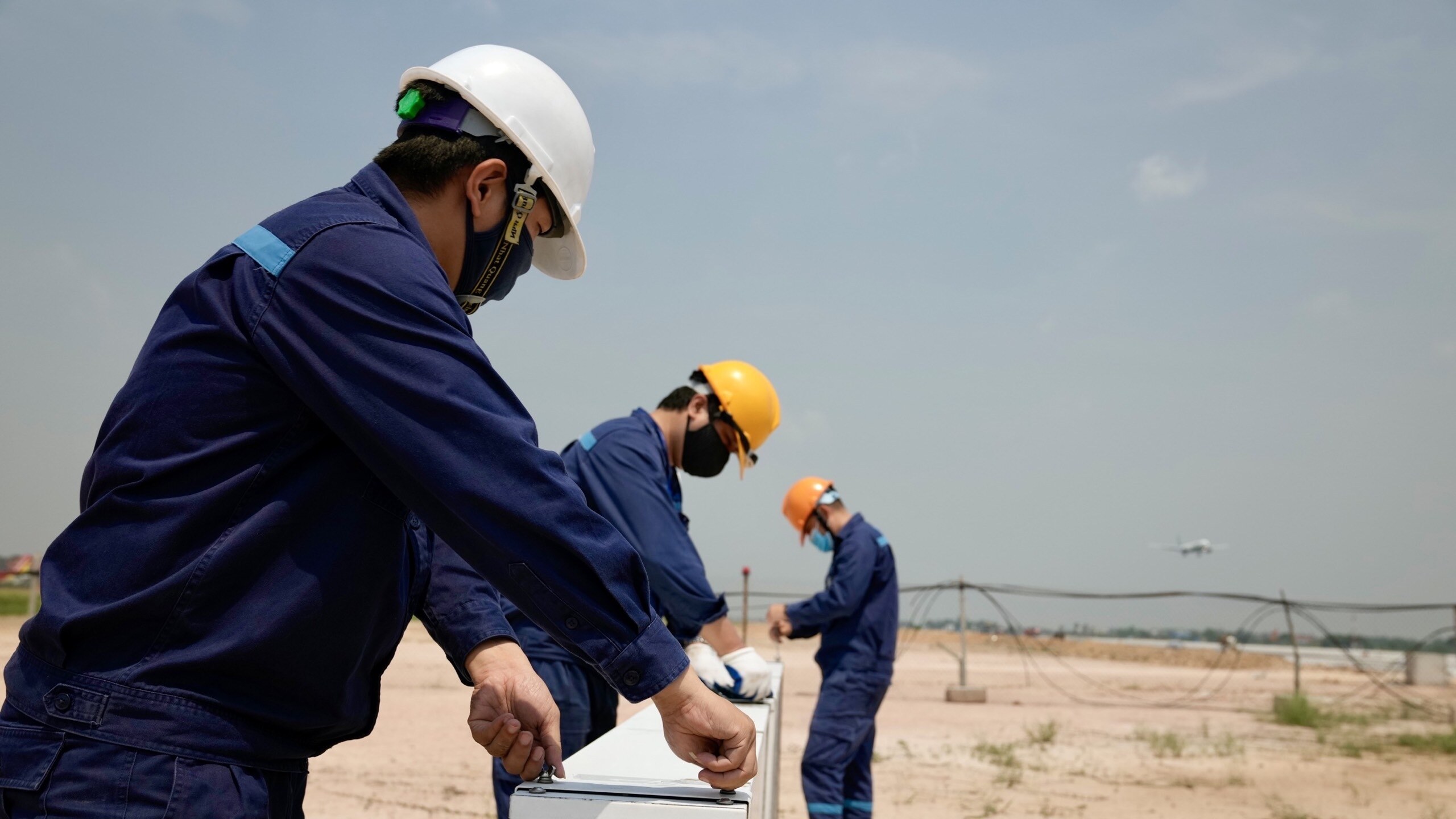 Trong khu bay, giữa trời nắng n&oacute;ng l&ecirc;n tới 60 độ, nh&acirc;n vi&ecirc;n vẫn miệt m&agrave;i thực hiện bảo tr&igrave; hệ thống biển b&aacute;o