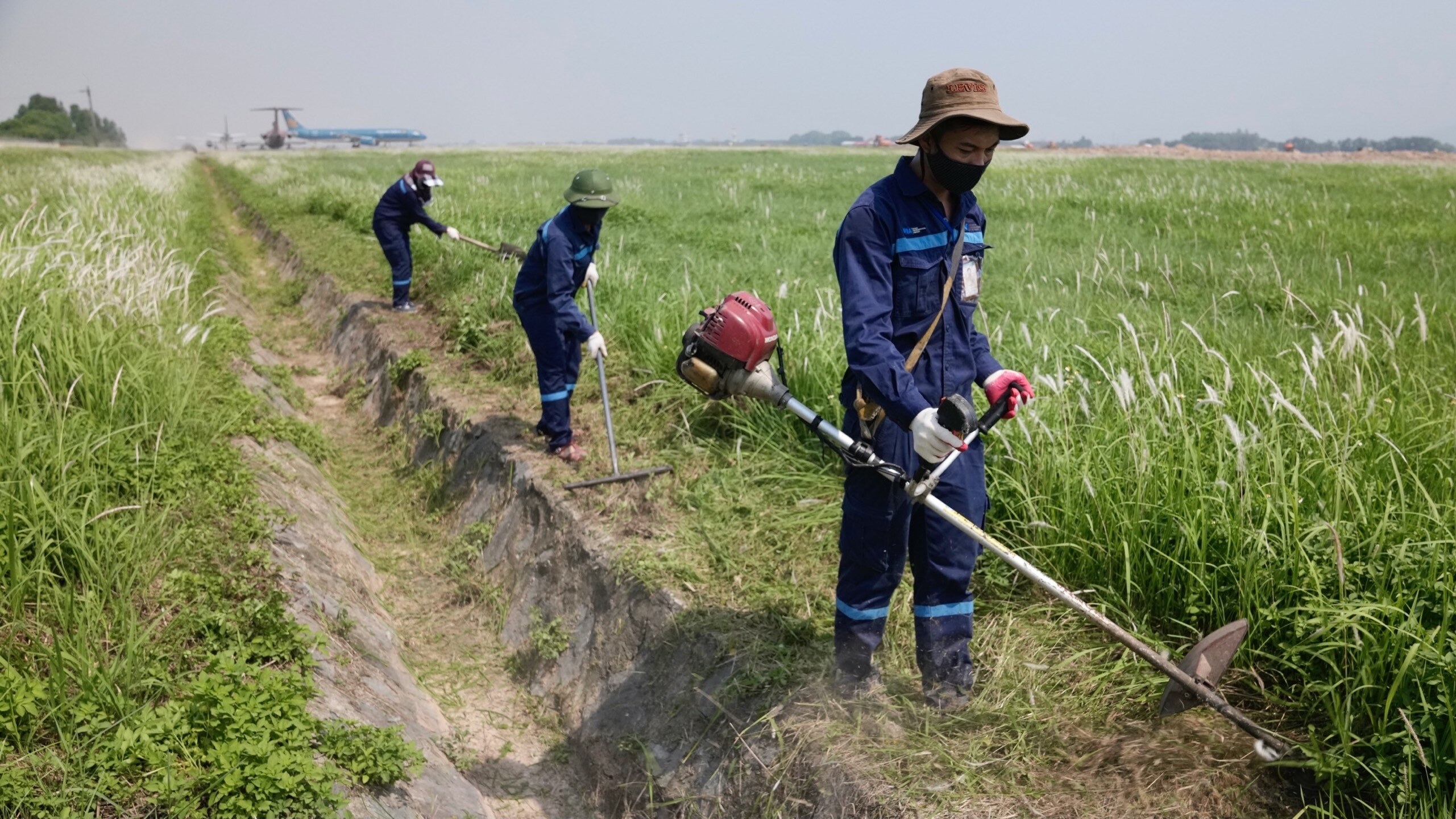 Đội bảo tr&igrave; s&acirc;n đường - Trung t&acirc;m Khai th&aacute;c khu bay Nội B&agrave;i - thực hiện nạo v&eacute;t mương