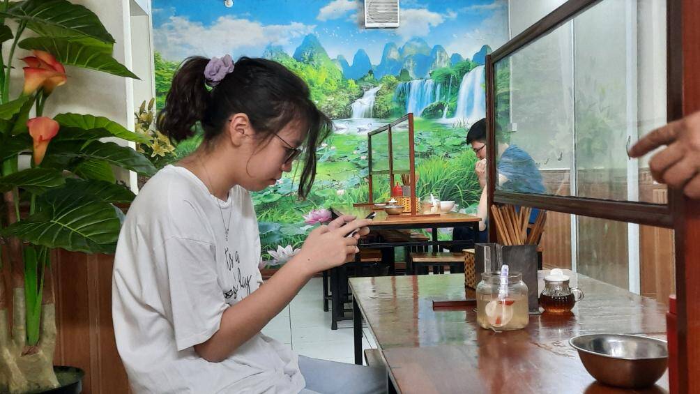 Cửa h&agrave;ng ngo&agrave;i đảm bảo khoảng c&aacute;ch theo quy định c&ograve;n thực hiện lắp tấm chắn giữa người với người.