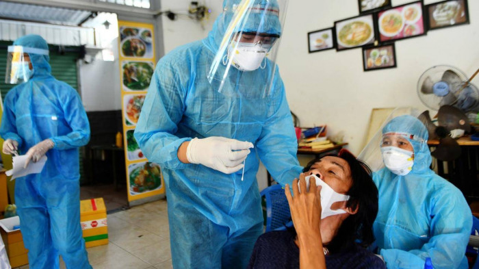 Lực lượng y tế lấy mẫu x&eacute;t nghiệm Covid-19 tại một khu d&acirc;n cư ng&agrave;y 2/7