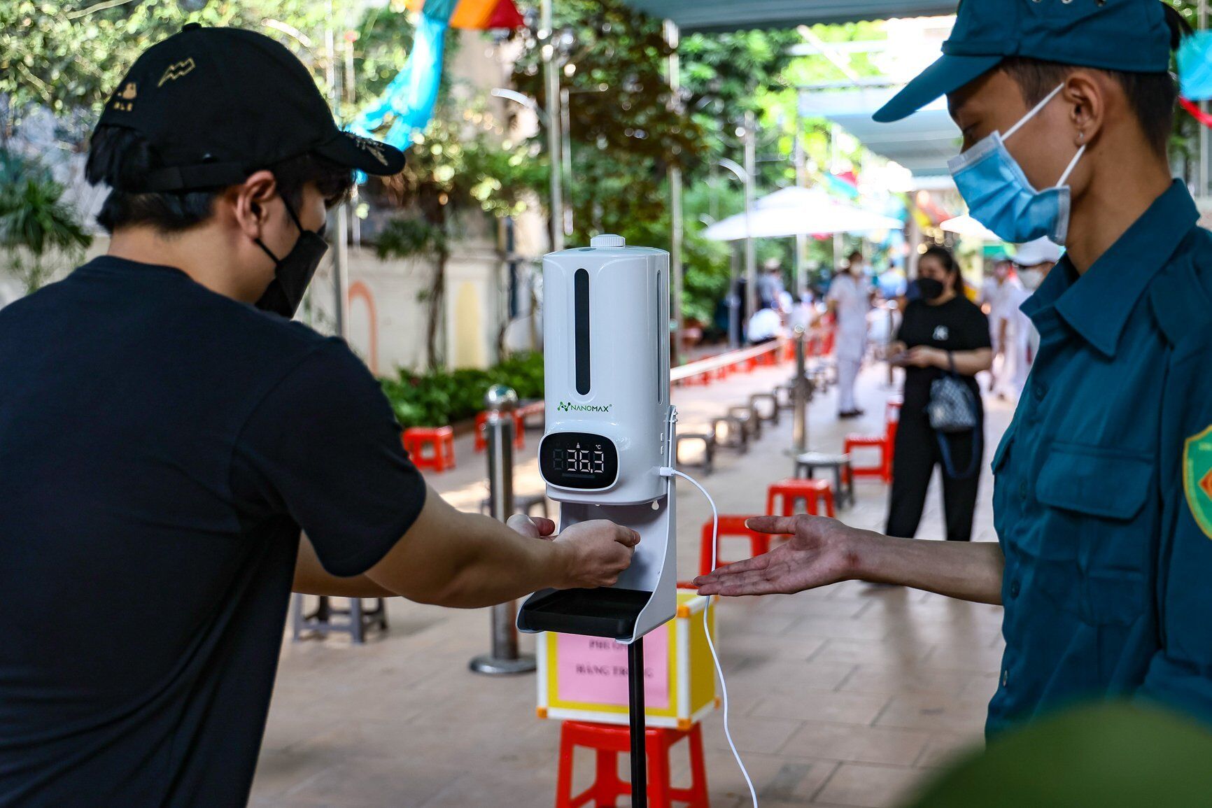 Trước khi v&agrave;o địa điểm ti&ecirc;m vaccine, người d&acirc;n phải tu&acirc;n thủ nghi&ecirc;m ngặt c&aacute;c quy định ph&ograve;ng chống dịch như s&aacute;t khuẩn tay, đeo khẩu trang.