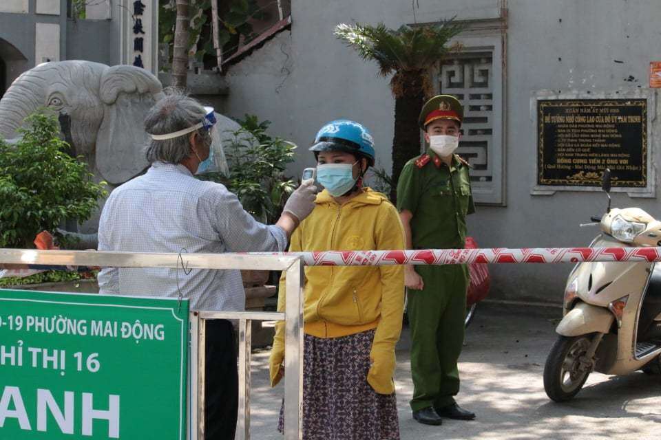 Người d&acirc;n đều đồng l&ograve;ng, vui vẻ, tự nguyện thực hiện c&aacute;c nội quy, bảo ban nhau nhằm bảo vệ "v&ugrave;ng xanh an to&agrave;n" của khu d&acirc;n cư m&igrave;nh sinh sống. Ảnh chụp người d&acirc;n đo nhiệt độ để ra/v&agrave;o "v&ugrave;ng xanh an to&agrave;n" ở khu d&acirc;n cư 1, phường Mai Động s&aacute;ng 3/8.