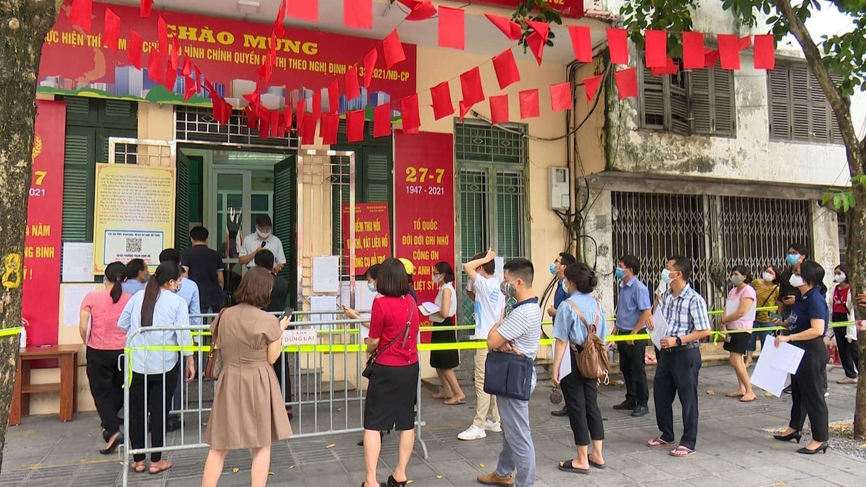 Trước trụ sở phường Ng&ocirc; Th&igrave; Nhậm, quận Hai B&agrave; Trưng, người d&acirc;n cũng xếp h&agrave;ng từ trước giờ l&agrave;m việc buổi chiều để xin giấy đi đường.